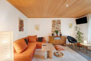 a living room with an orange couch and a table at Hornihäusle in Aufʼm Bühl