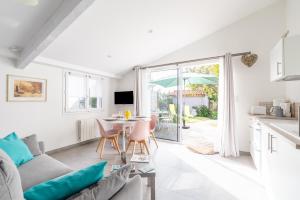 a living room with a couch and a table at Bois Flottés - Maisonnette 700m mer in Pornic +16 photos