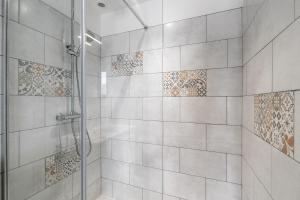 a bathroom with a shower with tiled walls at Bois Flottés - Maisonnette 700m mer in Pornic
