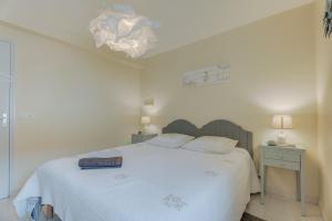 a bedroom with a white bed with a white blanket at Côte d'emeraude in Saint-Benoît-des-Ondes
