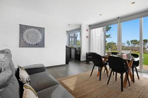 ein Wohnzimmer mit Sofa und Tisch in der Unterkunft Rocha do Mar 1 in Biscoitos