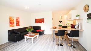 a living room with a black couch and a table at Ferienwohnung auf Ferienhof Janssen in Wangerland