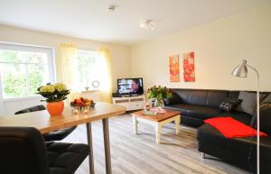 a living room with a couch and a table at Ferienwohnung auf Ferienhof Janssen in Wangerland