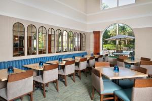 a restaurant with tables and chairs and windows at Hawthorn Suites by Wyndham Naples in Naples