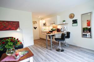 a living room with a table and a kitchen at Ferienwohnung auf Ferienhof Janssen in Wangerland +8 photos