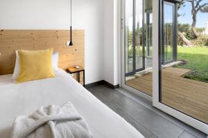 ein Schlafzimmer mit einem Bett und einer Glasschiebetür in der Unterkunft Rocha do Mar 1 in Biscoitos + 27 Fotos