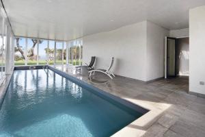 ein Swimmingpool mit zwei Stühlen in einem Haus in der Unterkunft Rocha do Mar 1 in Biscoitos