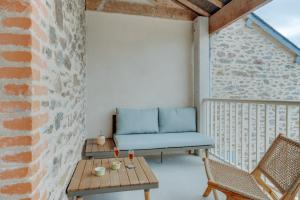 a patio with a couch and a table and chairs at Les Ebihens in Saint-Benoît-des-Ondes
