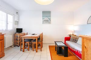 a living room with a table and a couch at Location Oléron, proche plage in Dolus-d'Oléron