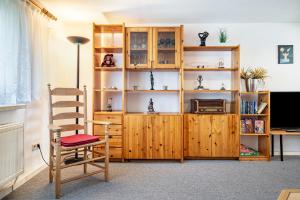 a room with a wooden book shelf and a chair at Ferienwohnungen in Starsow in Mirow
