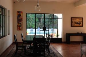 a dining room with a table and a large window at Villa Marines Cuernavaca in Cuernavaca