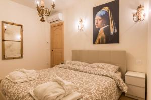 a bedroom with a bed with a painting on the wall at Wellness Lodge Edoardo in Santa Giuliana