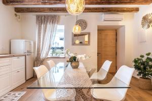 a dining room with a glass table and white chairs at Wellness Lodge Edoardo in Santa Giuliana +19 photos
