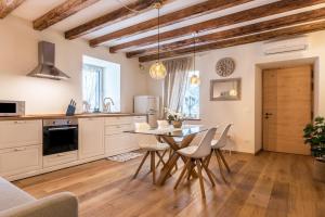 a kitchen and dining room with a table and chairs at Wellness Lodge Edoardo in Santa Giuliana