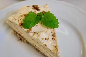 a piece of cake with a mint leaf on a plate at Tørvis Hotell in Luster +29 photos