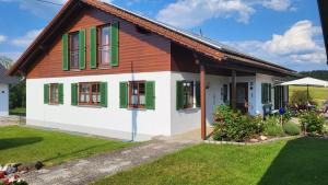 a small house with green and white windows at Ferienwohnung Strobl in Dießen am Ammersee