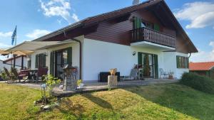 a house with a balcony and a yard at Ferienwohnung Strobl in Dießen am Ammersee +6 photos