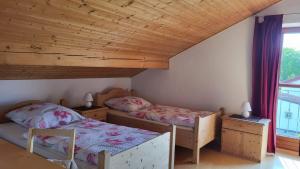 two beds in a room with wooden ceilings at Ferienwohnung Strobl in Dießen am Ammersee