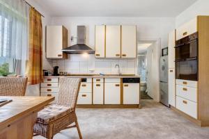 a kitchen with white cabinets and a table and chairs at Am Weserradweg in Porta Westfalica