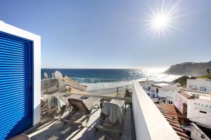 a balcony with chairs and a view of the ocean at Casinha in Burgau