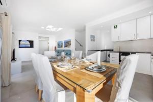 a kitchen and dining room with a wooden table and chairs at Casinha in Burgau