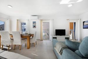 a living room with a table and a blue couch at Casinha in Burgau