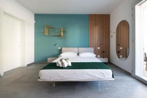 a bedroom with a large bed with a blue wall at Briamar Residence in Torre dell'Orso +97 photos