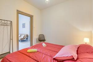 a bedroom with a bed with a red comforter at Appart - Sète quartier des Artistes in Sète