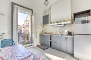 a kitchen with a refrigerator and a table and a window at Appart - Sète quartier des Artistes in Sète