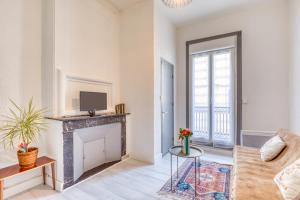 a living room with a fireplace and a tv at Appart - Sète quartier des Artistes in Sète