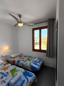 a bedroom with two beds and a window at Sol Isla - Binimar in Arenal d'en Castell +21 photos