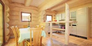a log cabin kitchen with a table and chairs at Seehaus Alm in Ruhpolding
