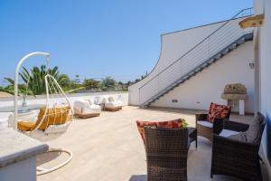 a patio with chairs and a hammock on a building at Villa Scoglio in Melendugno
