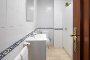 a white bathroom with a toilet and a sink at Valle Inclan in Villanueva de Arosa +17 photos