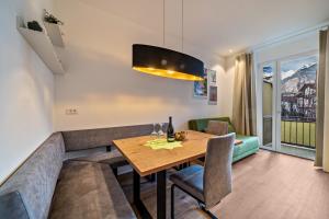 a dining room with a table and a couch at Central Suite Meran in Merano