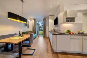 a kitchen with a wooden table and a dining room at Central Suite Meran in Merano