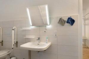 a white bathroom with a sink and a toilet at Ferienwohnung im Denkmal in Havelberg