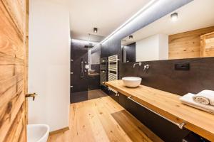 a bathroom with a wooden counter and a sink at Naturoase Stegerhof Apt Sonnenblume in Trodena +31 photos