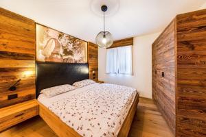 a bedroom with a bed with a wooden wall at Naturoase Stegerhof Apt Sonnenblume in Trodena
