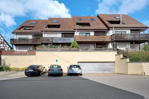 three cars parked in a parking lot in front of a building at Großzügige Maisonettewohnung in Sindelfingen