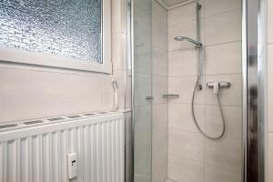 a bathroom with a shower with a glass door at Bodensee Apartment Gresser in Meckenbeuren +12 photos