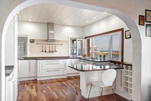a kitchen with white cabinets and a large window at El Mar y Tú in Arrieta
