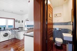 a bathroom with a sink and a washing machine at El Mar y Tú in Arrieta +19 photos