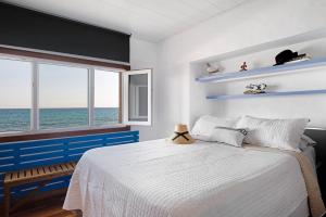 a bedroom with a bed with a view of the ocean at El Mar y Tú in Arrieta