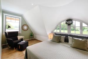 a bedroom with a bed and a chair and windows at Ferienhaus Weltenbummler in Pepelow
