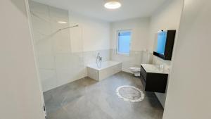 a bathroom with a tub and a toilet and a sink at Ferienhaus Koca in Imsterberg +22 photos