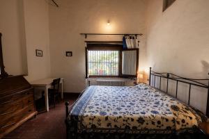 a bedroom with a bed and a desk and a window at Vallone di Cecione in Greve in Chianti