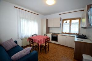 a living room with a table and a kitchen at Ciasa Da Rin in Auronzo di Cadore