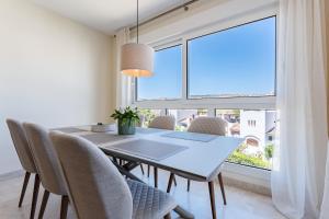 a dining room with a table and chairs and a large window at Apartamento Los Iris in Mijas