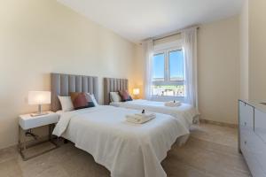 a bedroom with two beds and a window at Apartamento Los Iris in Mijas +13 photos